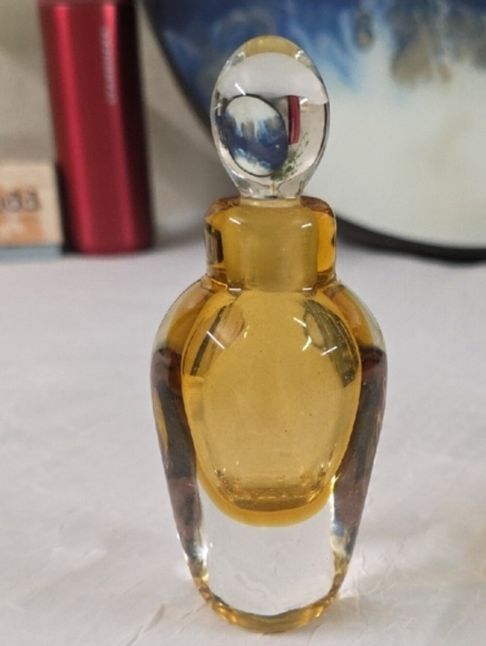Beautiful glass perfume bottle with a clear and amber design. Features a rounded